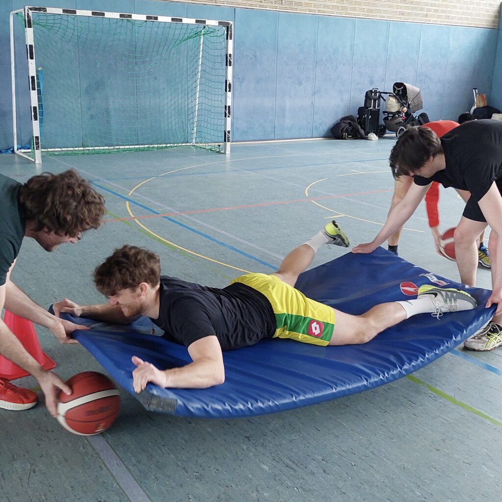 Das Yolawo-Team spielt Sportspiele in der Turnhalle in Frankfurt.