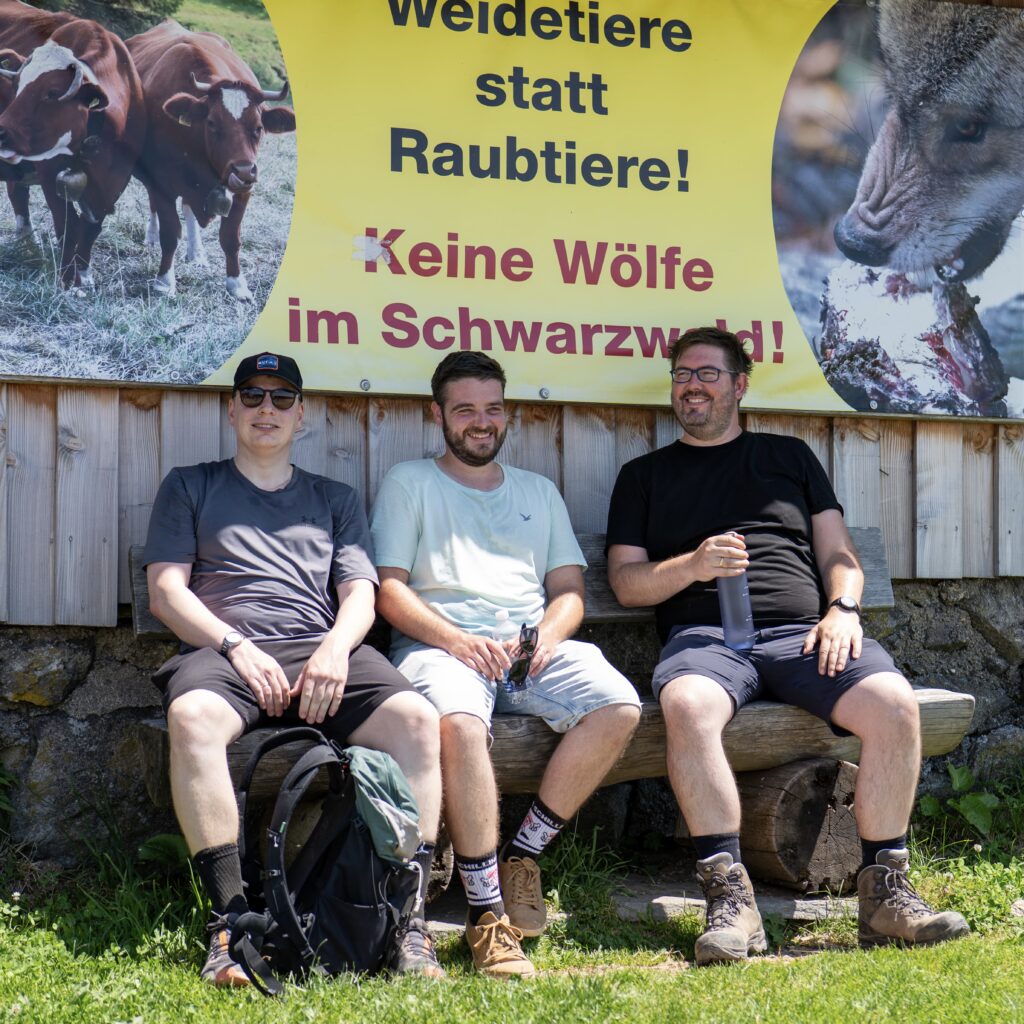 Das Yolawo-Team macht Pause auf einer Bank beim Wandern.